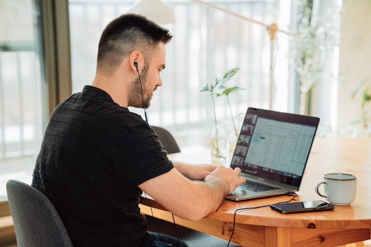 photo of student taking a class live online, seated at a table at home